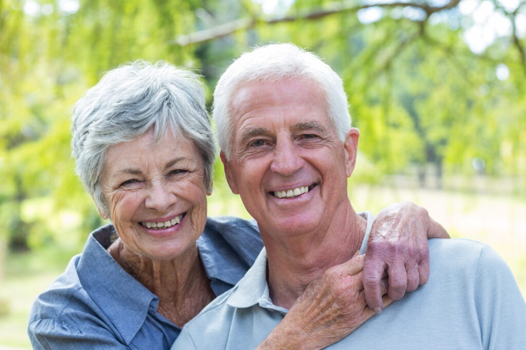 Image of a independent senior couple enjoying the outdoors smiling at the camera.