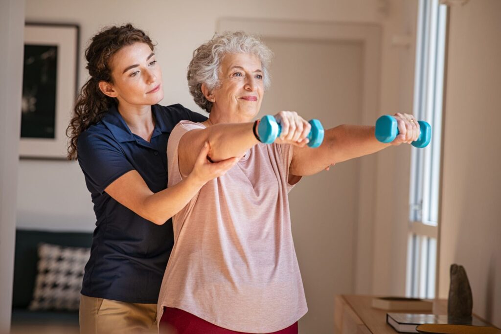 Rehabilitation and Transitional Care Lifestyle box. An image of a senior women in a therapy session with weights and assisted by a young PT women.